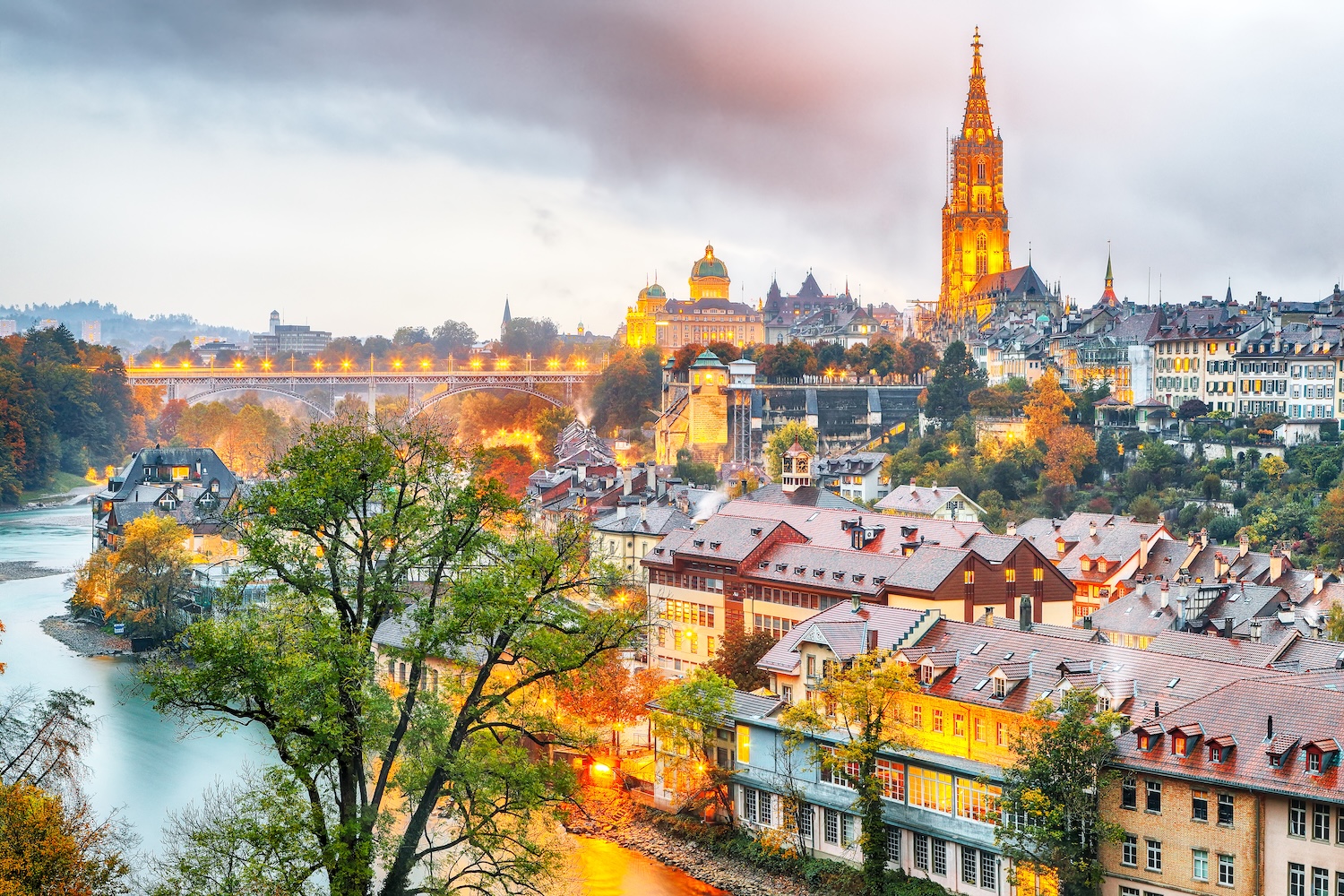 Amazing autumn view of Bern city on Aare river during evening with Cathedral of Bern on background.