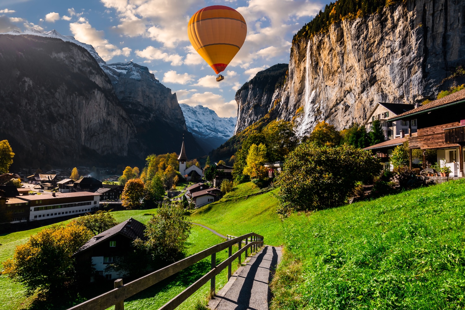 Hot air balloon over Lauterbrunnen, Switzerland — alpine valley with mountains and waterfalls