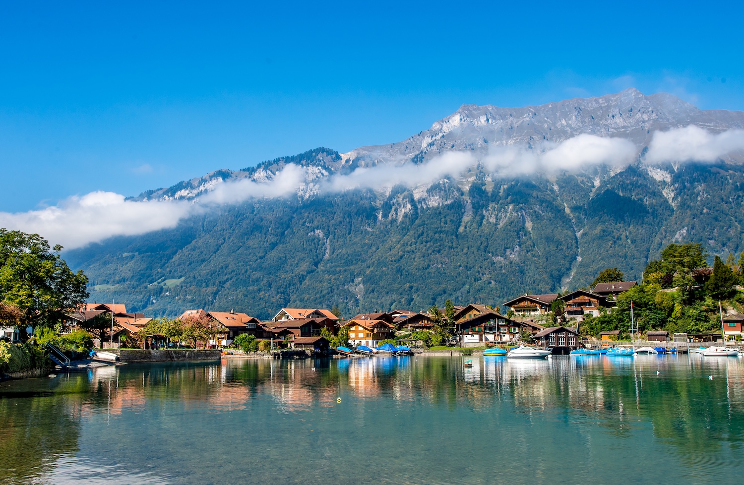 Scenery Of Fishing Village Close To Interlaken Over Cloudy Alps On Lake Brienz, Switzerland.